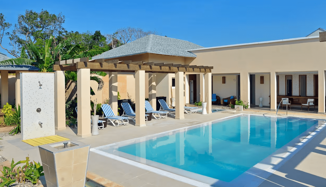 Outdoor pool with lounge chairs and pergola.