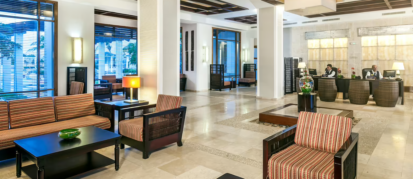 Hotel lobby with reception desk and seating.