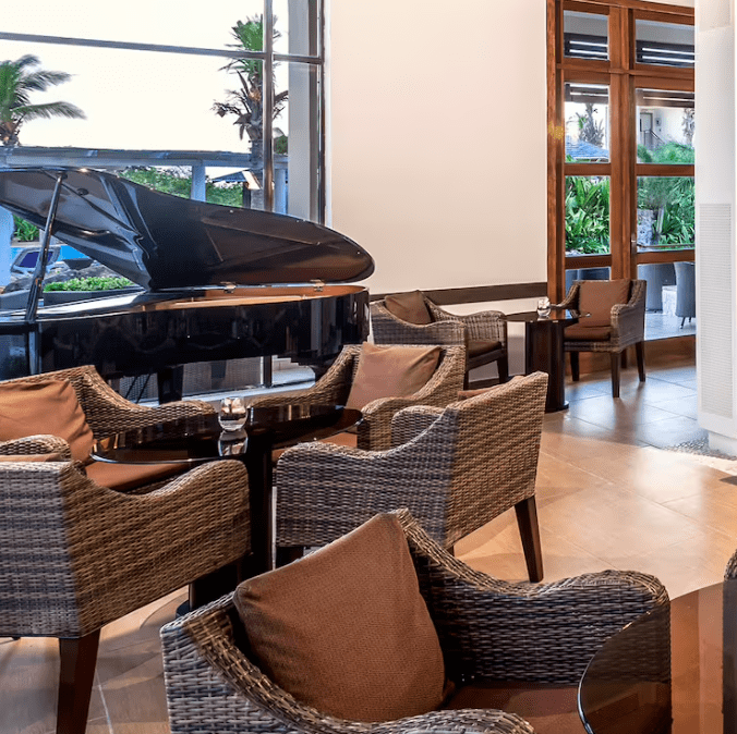 Grand piano and wicker chairs in a lobby.