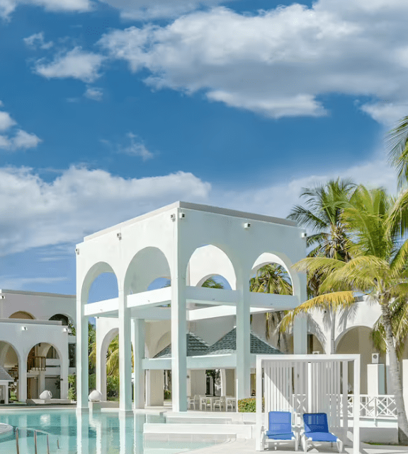 White resort pool with palm trees.