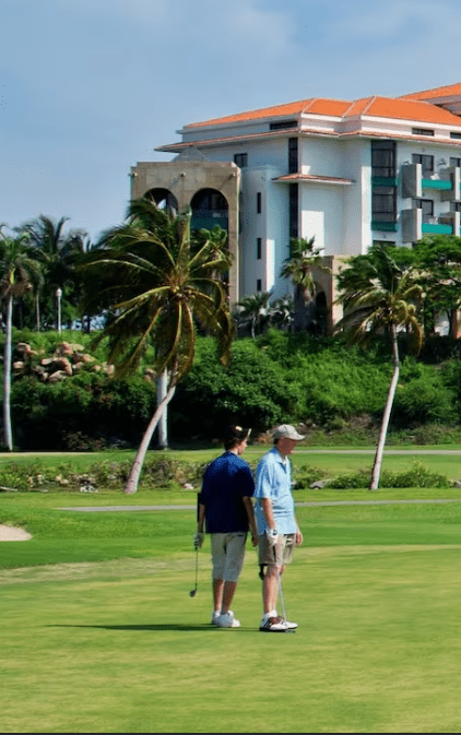 Two golfers on green course by resort.