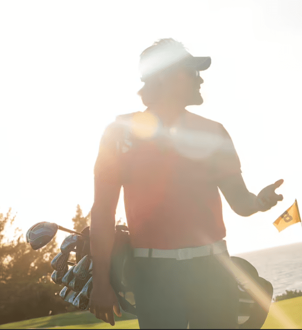 Golfer with bag and clubs on course.