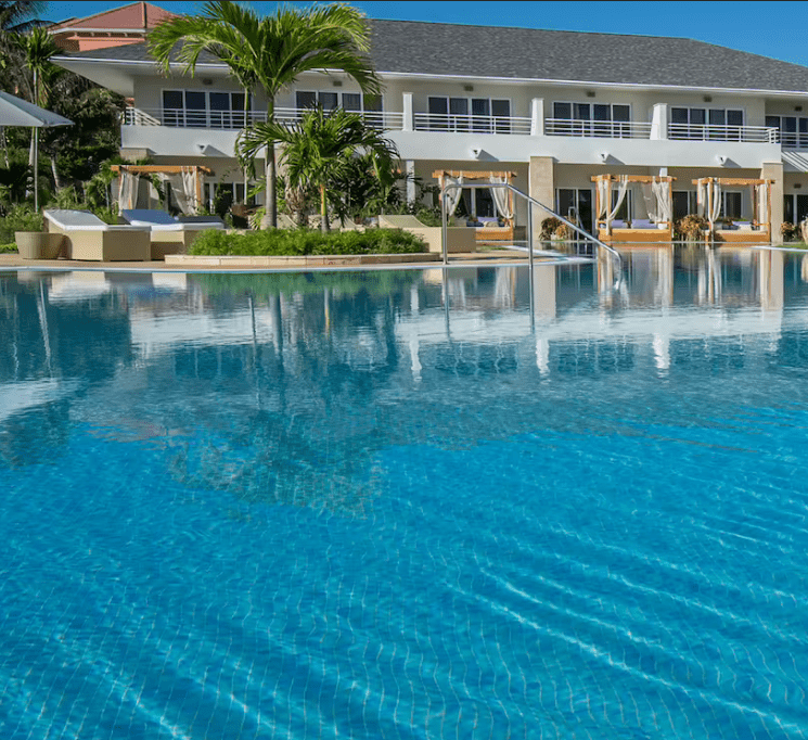 Blue pool reflecting a resort building.