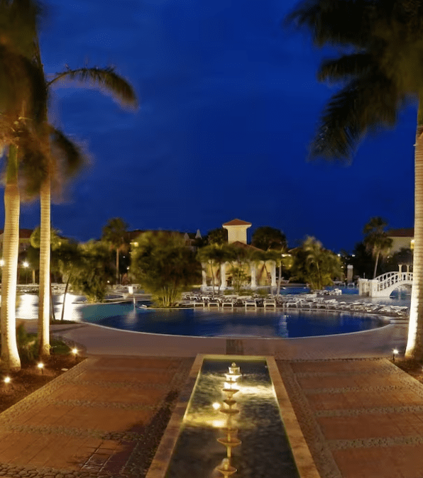 Night view of resort pool and fountain.