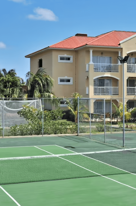 Tennis court in front of resort building.