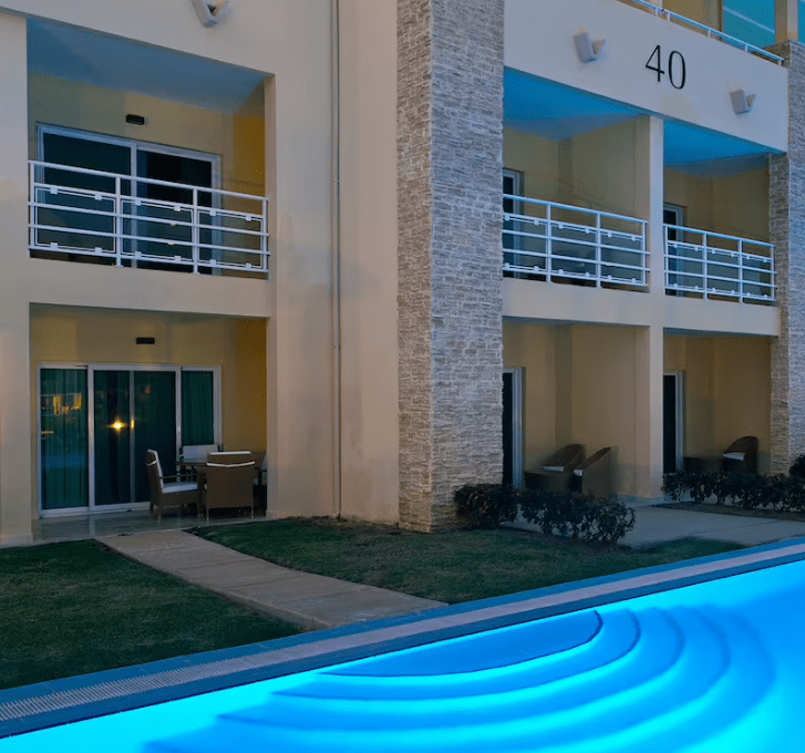 Hotel building with a pool in front.