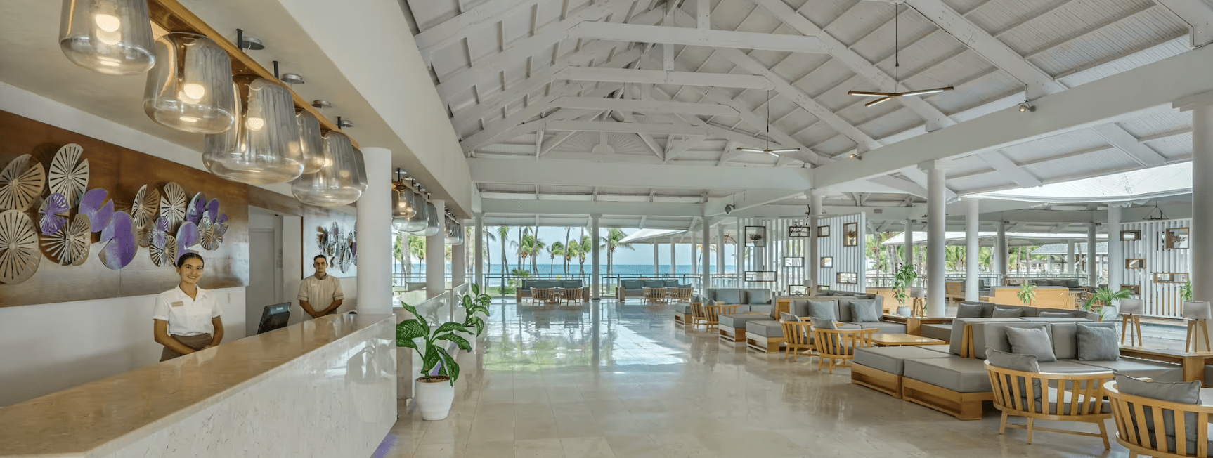 Hotel lobby with beach view and staff.