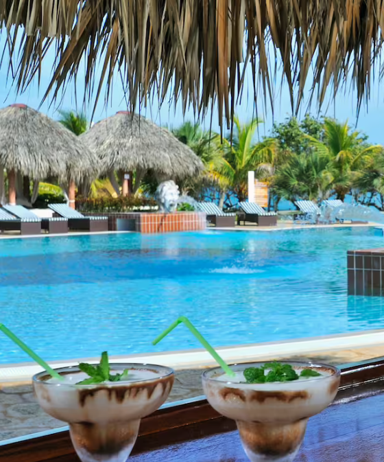 Two cocktails by a pool in a resort.