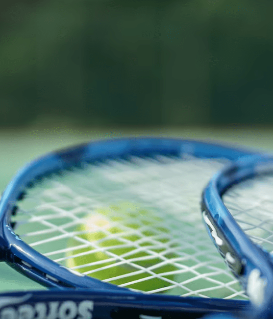 Close-up of two tennis rackets and ball.