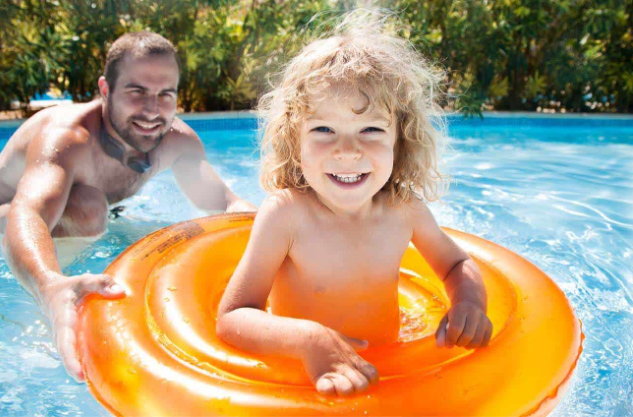 Young girl smiling in inflatable ring pool.