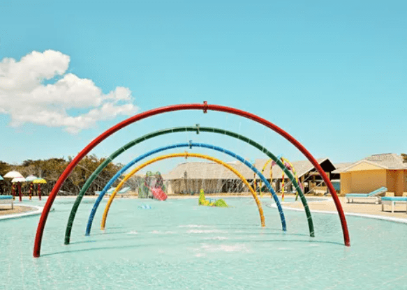 Rainbow water sprinklers in a pool.