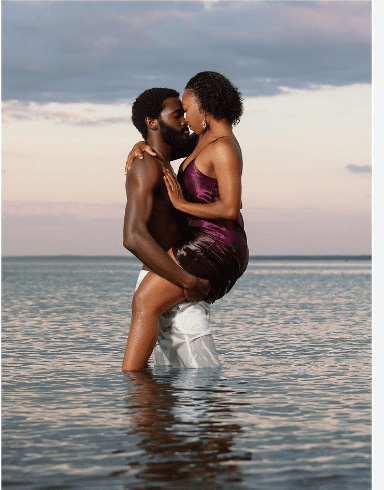 Couple kissing in shallow water.