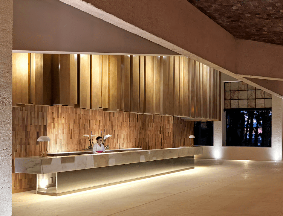 Modern hotel reception with a woman standing.