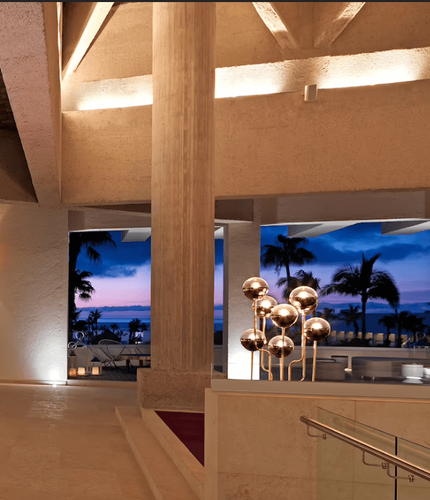 Modern lobby with sunset view and sculptures.