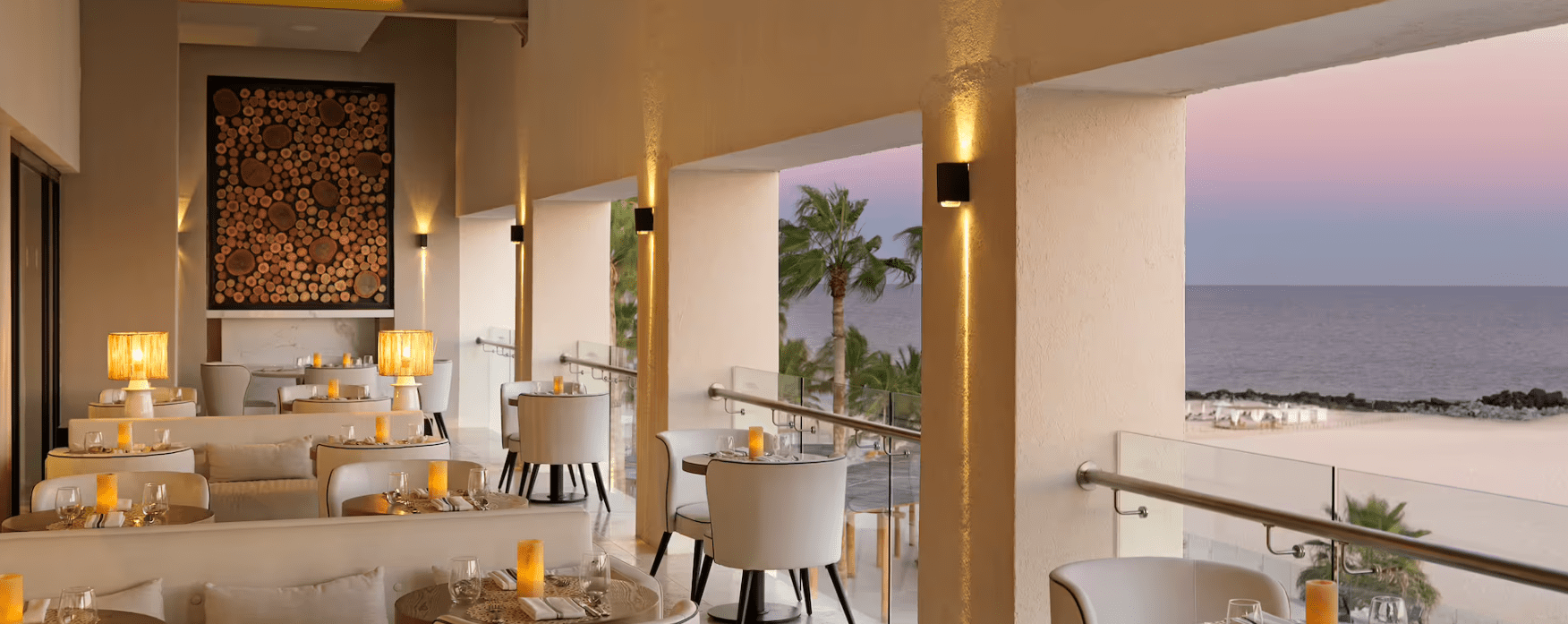 Ocean view dining room with white chairs.