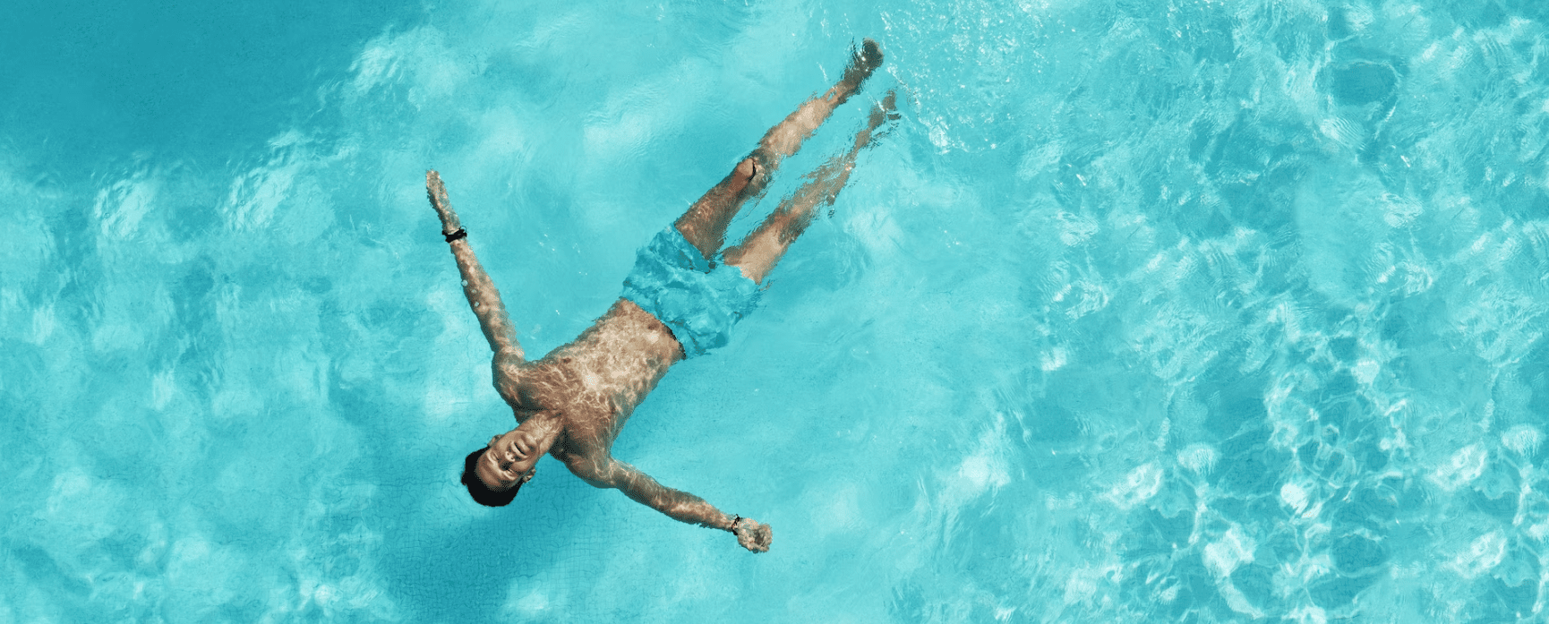 Man floating on his back in pool.