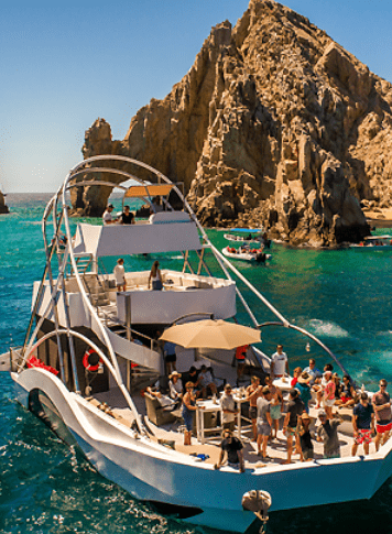 Boat tour with people near a rock arch.