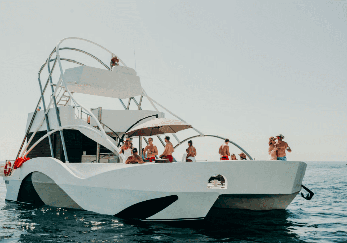 White yacht with people on board.