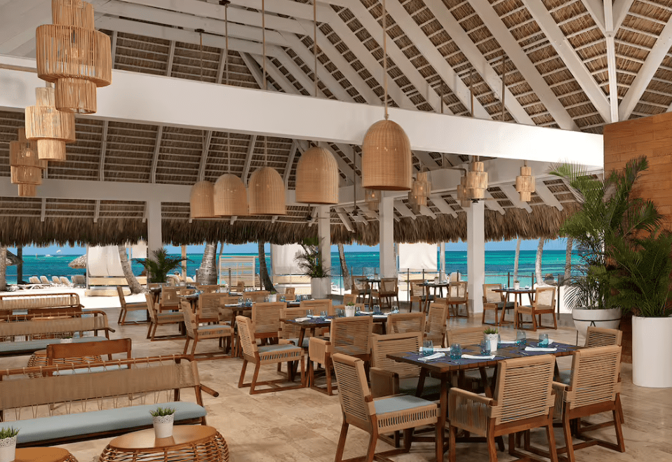 Beachfront restaurant with rattan furniture.