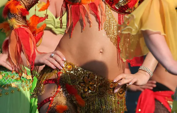 A woman in a colorful costume is posing for a photo.