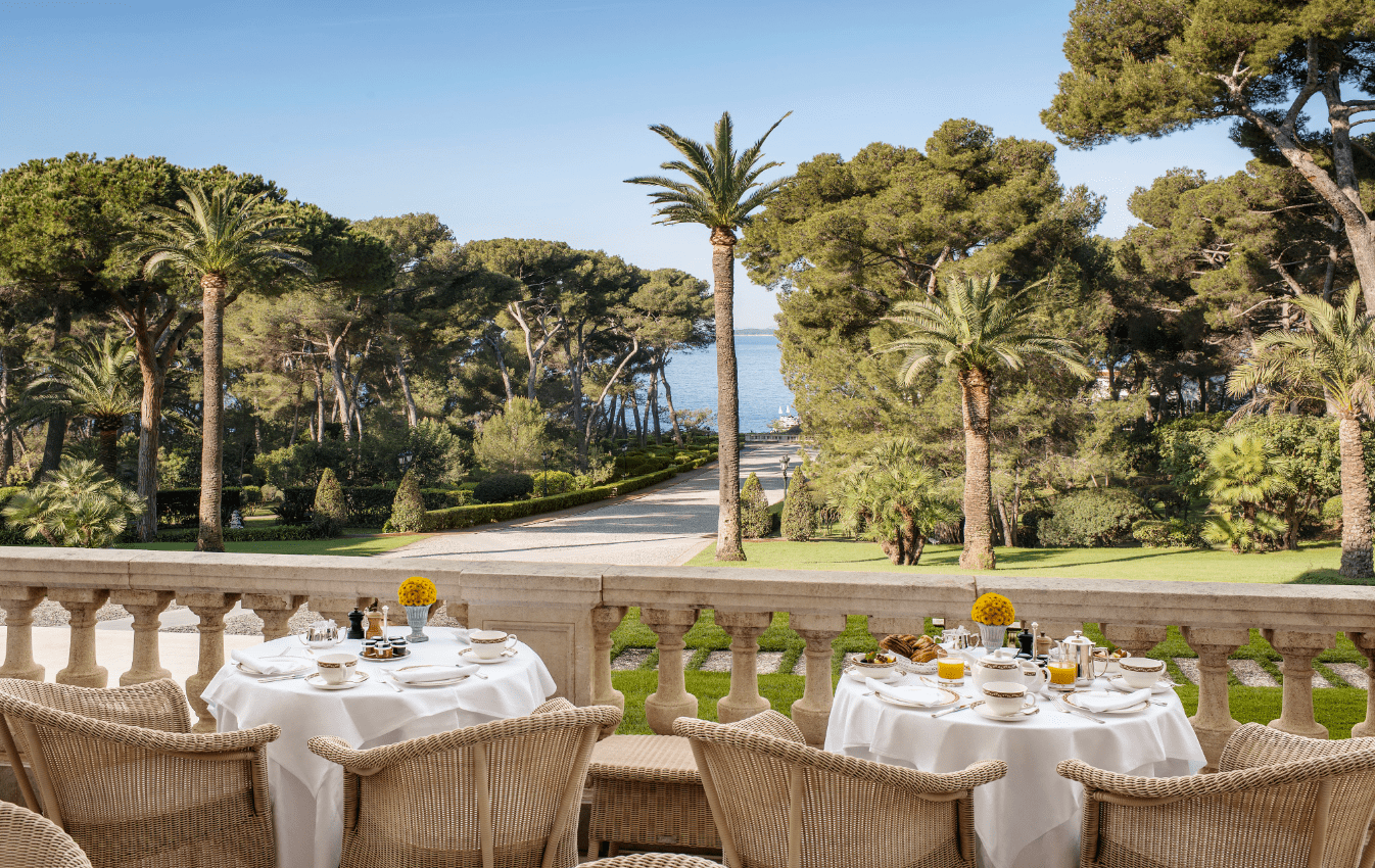 A table is set on a balcony overlooking the ocean.