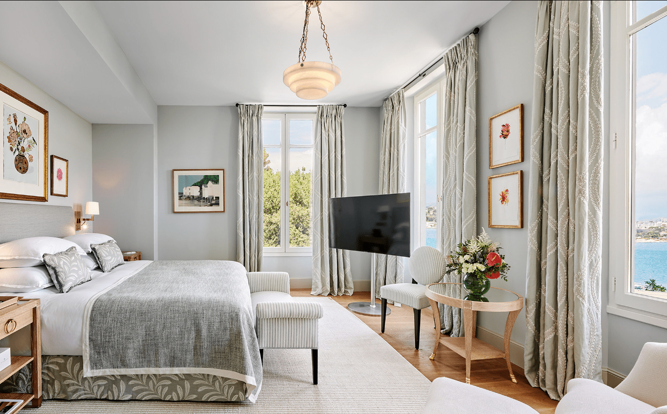 A bedroom with a large bed and a view of the ocean.