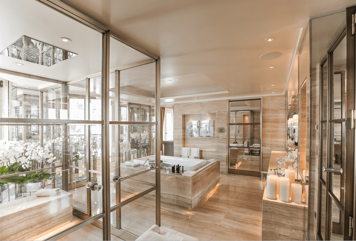 Luxurious bathroom with marble tiles and glass walls.