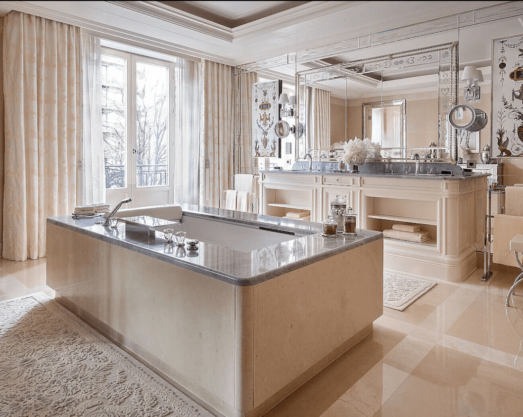 Luxurious bathroom with marble bathtub and golden fixtures.