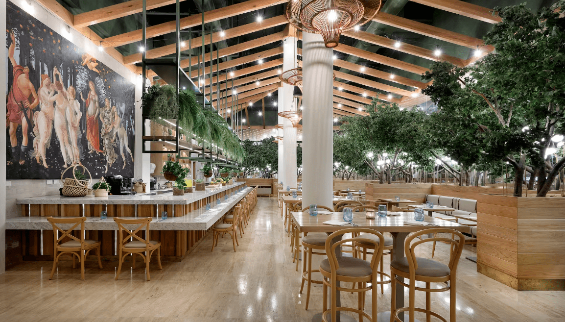 Elegant dining room with trees and mural.