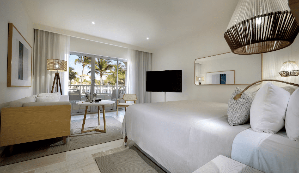 Hotel room with a king bed and a seating area.