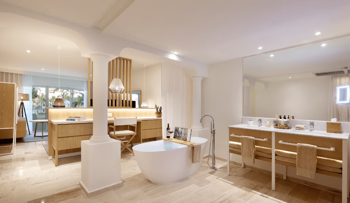 Bathroom with bathtub, double vanity, and separate toilet.