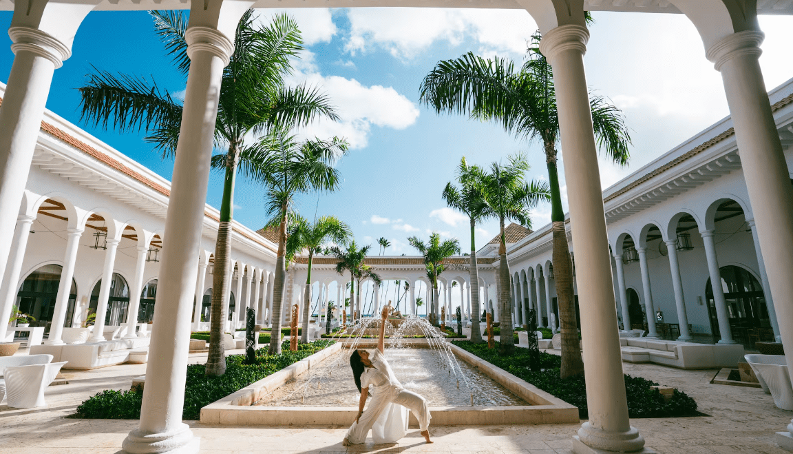 Woman doing yoga in a tropical courtyard.