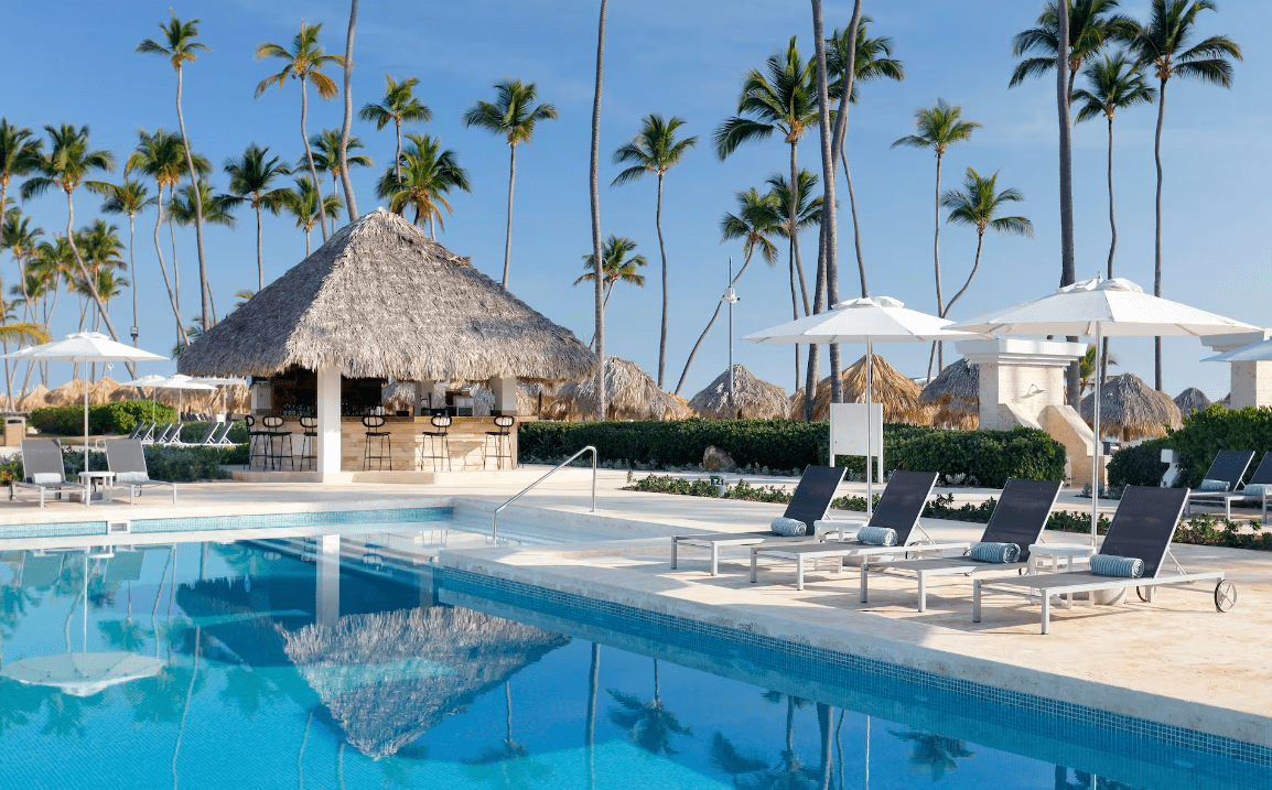 Palm trees by a pool with a bar.