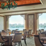 Restaurant with city view and chandelier.