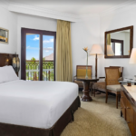 Hotel room with balcony view and king bed.