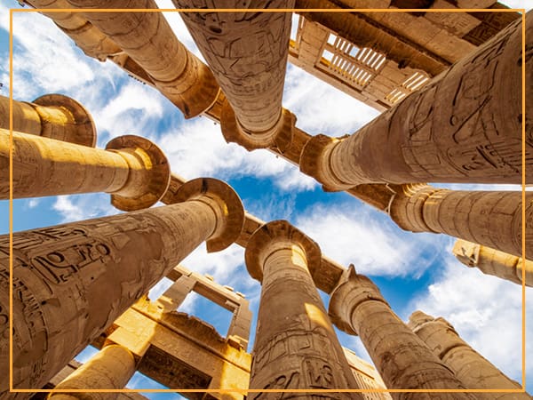 Ancient Egyptian temple columns against a blue sky.