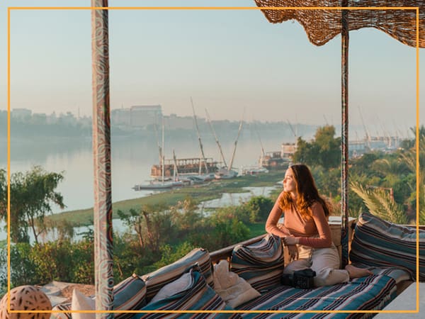 Woman relaxing on a patio overlooking a river.