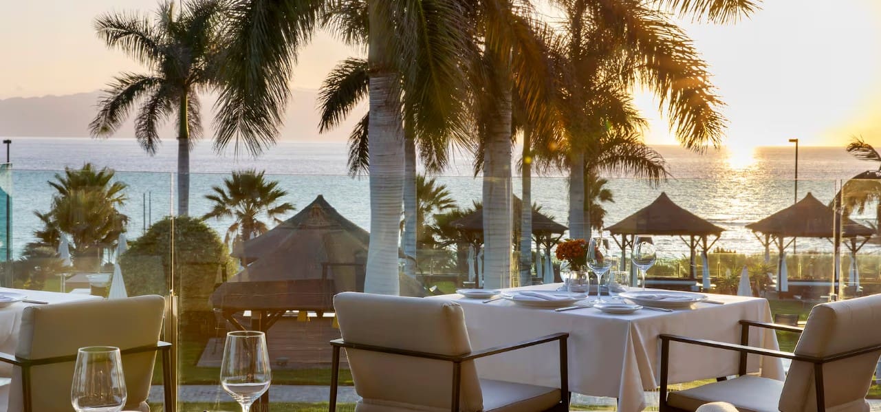 Oceanfront table setting with sunset view.