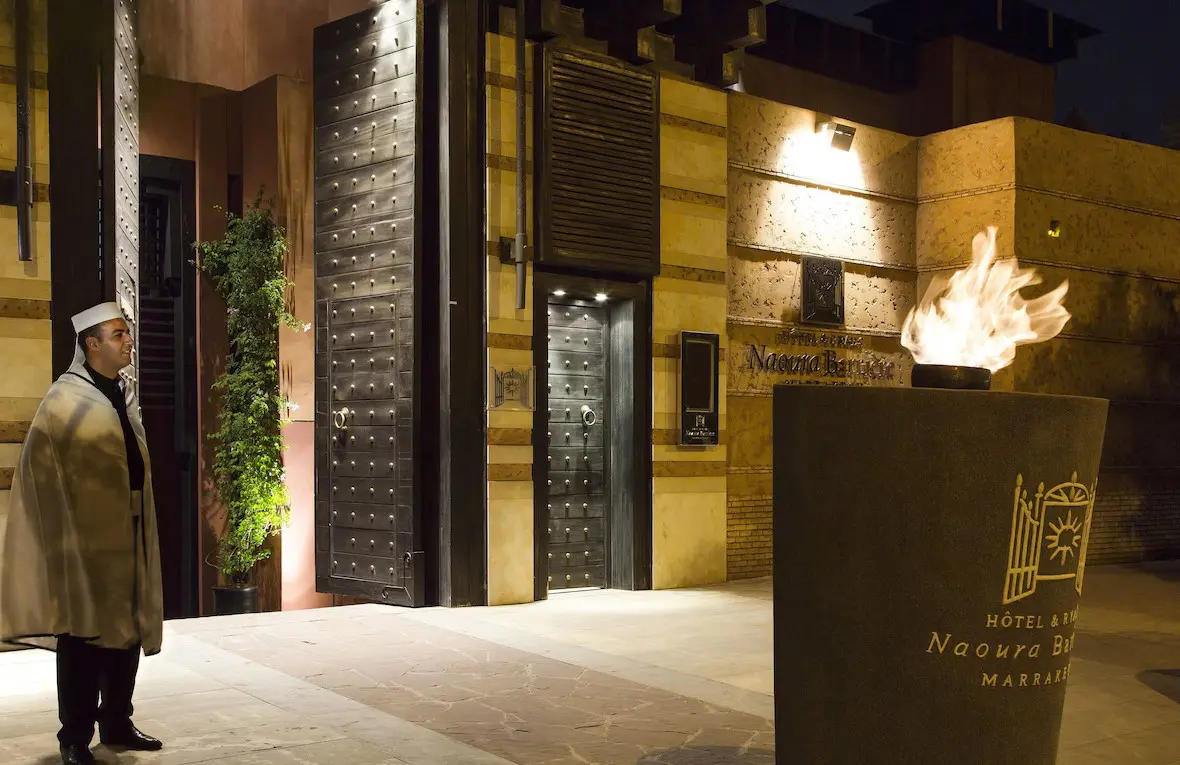 Man in front of hotel entrance with flame.