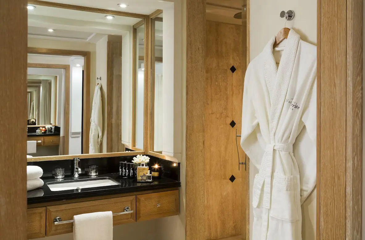 White bathrobe hanging in bathroom.