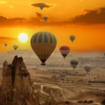 Hot air balloons over Cappadocia at sunset.