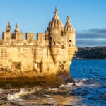 Historic castle by the water at sunset.