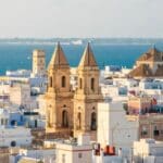 Coastal city skyline with historic buildings.