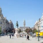 City square with statue and historic buildings.