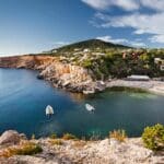 Scenic coastal view with boats and greenery.