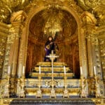 Golden altar with religious statue and paintings.