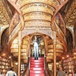 Woman on ornate staircase in a library.