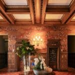 Elegant foyer with floral wallpaper and decor.