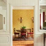 Elegant dining area with yellow wallpaper.