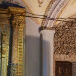 Gold altar next to wall of skulls.